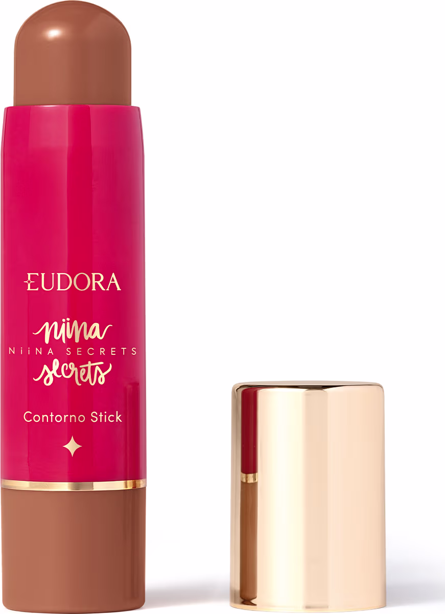 O produto apresentado é um contorno em bastão da linha Niina Secrets. A embalagem é cilíndrica e de cor rosa vibrante, com o nome da marca e da linha impressos em letras douradas. A embalagem também possui um detalhe dourado na parte superior.