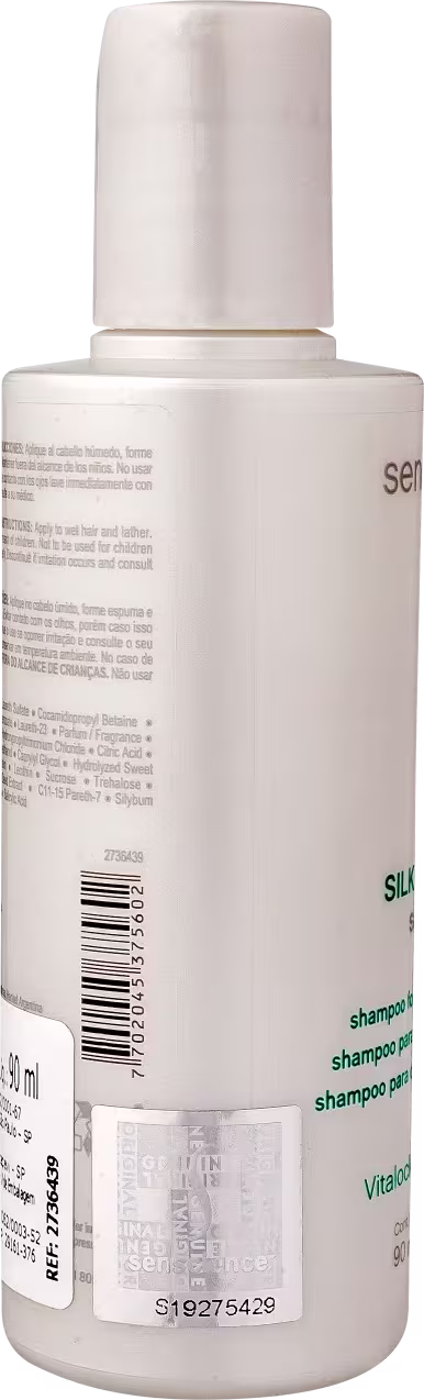 Shampoo em frasco plástico branco opaco de 50ml. Rótulo com texto "shampoo" em letras minúsculas nas cores branca e verde. Código de barras e número de lote visíveis na parte inferior do frasco.