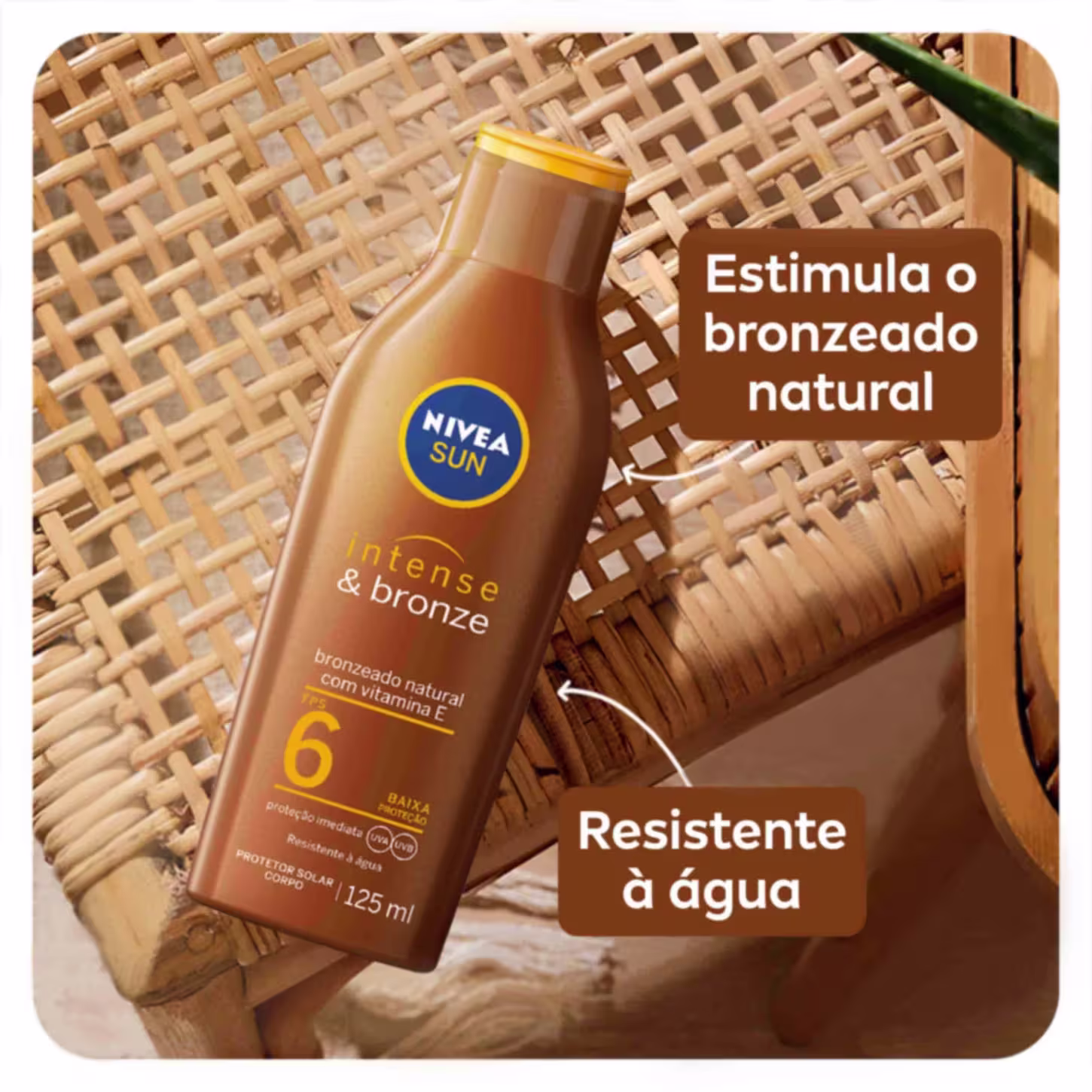 A imagem mostra o frasco plástico marrom com tampa amarela com a loção bronzeadora. As cores predominantes são marrom, amarelo e branco. O frasco está sobre uma superfície artesanal que parece uma cadeira ou mesa trançada.