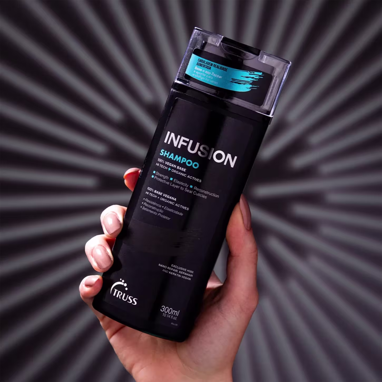 A imagem mostra uma mão feminina segurando o shampoo Infusion, com fundo radial cinza e preto.