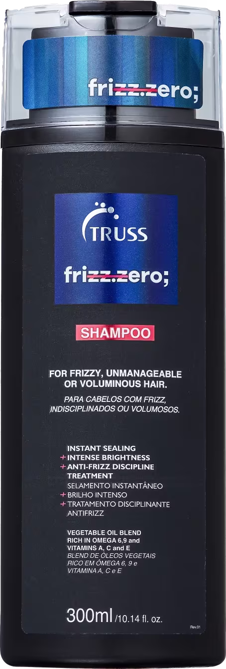 Frasco preto de 300ml com tampa transparente. Rótulo azul e branco com o logotipo da marca e o nome do produto "Frizz.Zero Shampoo". Para cabelos frisados, indisciplinados ou volumosos, com selante instantâneo, brilho intenso e tratamento disciplinante.