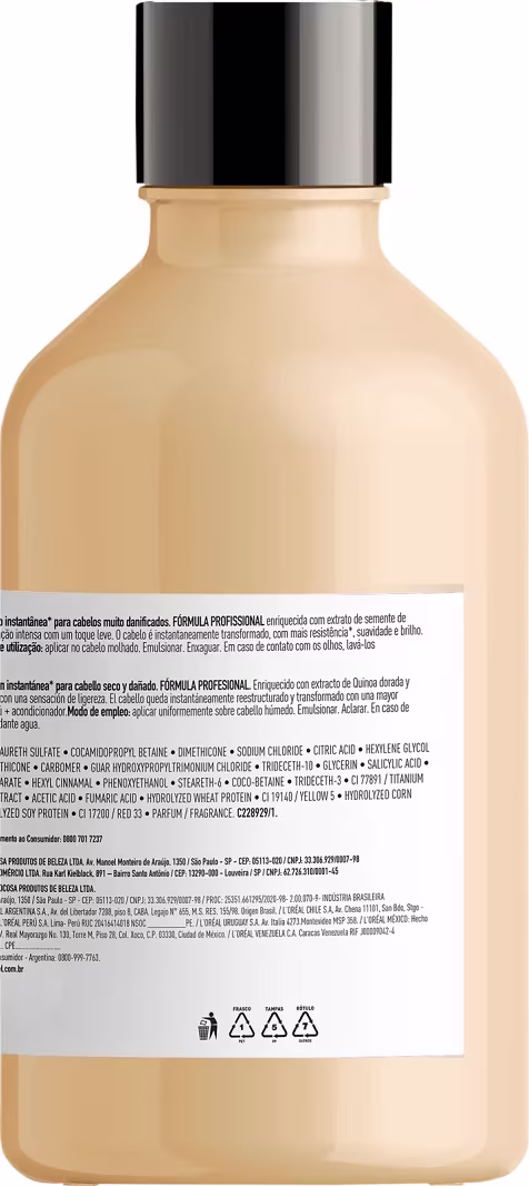 Este é um frasco de plástico transparente na cor bege, com uma tampa preta brilhante. Na parte inferior do frasco, há um rótulo com texto em várias línguas, listando ingredientes e informações do produto. Também há símbolos de advertência gráficos.