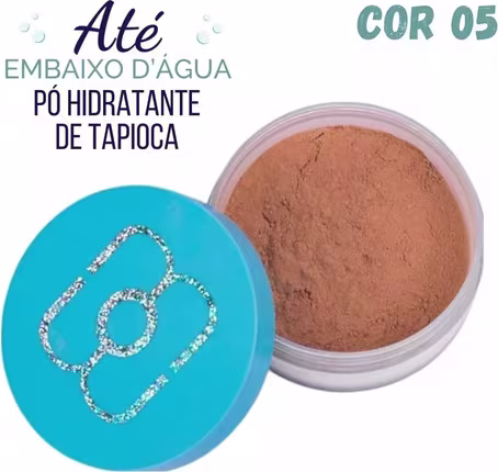 Pó compacto de maquiagem em embalagem plástica transparente. O pó tem uma tonalidade marrom terrosa. A tampa é azul turquesa e exibe um logotipo estilizado em glitter prateado.