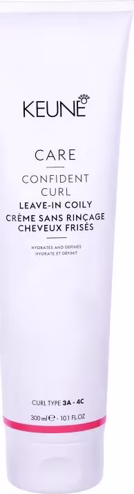 O produto apresentado é um creme leave-in da linha Confident Curl da marca Keune. A embalagem é um tubo branco com o logotipo da marca e o nome do produto "Confident Curl Leave-in Coily Creme".