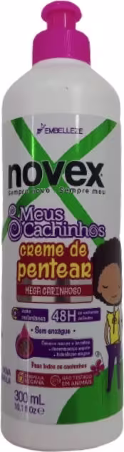 A imagem mostra o Creme para Pentear Novex Meus Cachinhos Creme de Pentear 300ml, da Embelleze. O frasco tem o fundo branco, com detalhes em verde e rosa e ilustração de uma criança com cabelo cacheado.