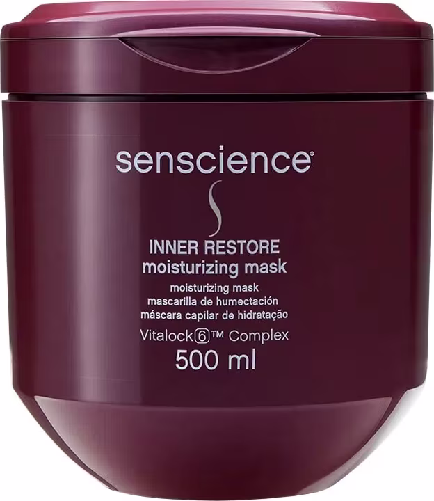 A imagem mostra o pote de máscara capilar que é de plástico rígido na cor vinho, com formato arredondado e tampa na mesma tonalidade. Na frente do pote, está impresso o nome do produto em letras brancas, junto com o logotipo da marca.