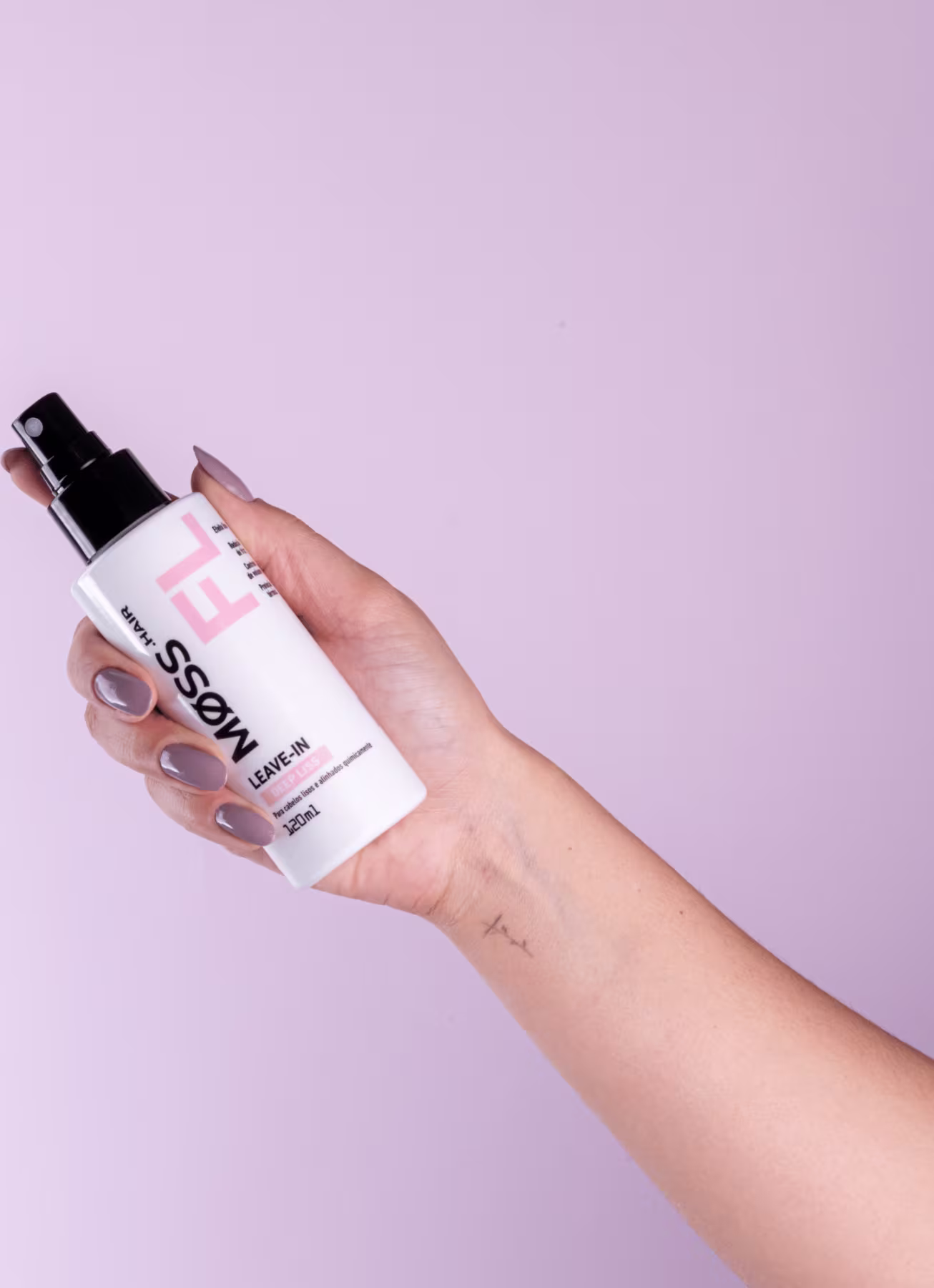 A imagem mostra uma mão segurando o frasco do leave-in deep liss em um fundo lilás.