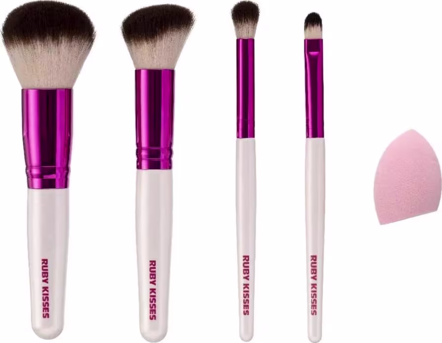 A imagem mostra quatro pincéis de maquiagem com cabo branco, detalhe rosa cromado e cerdas brancas com pontas escuras, além de uma esponja de maquiagem rosa.