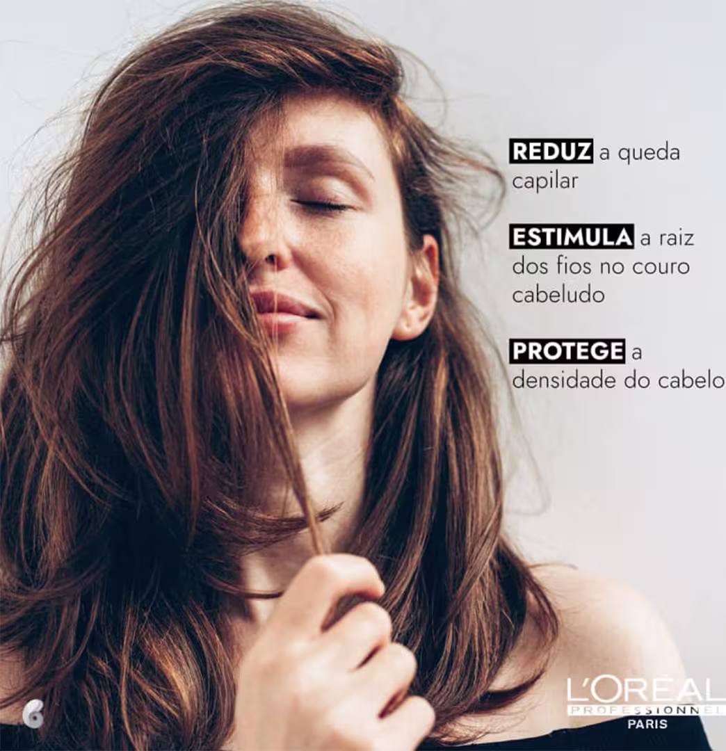 Mulher com cabelos longos e ondulados de cor castanha. O texto indica que o produto é da linha L'Oréal Professionnel e tem as funções: "REDUZ a queda capilar", "ESTIMULA a raiz dos fios no couro cabeludo" e "PROTEGE a densidade do cabelo".