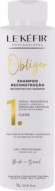 A imagem mostra um frasco branco de shampoo. A embalagem contém 1L e apresenta detalhes em letras douradas, com os principais ingredientes listados.