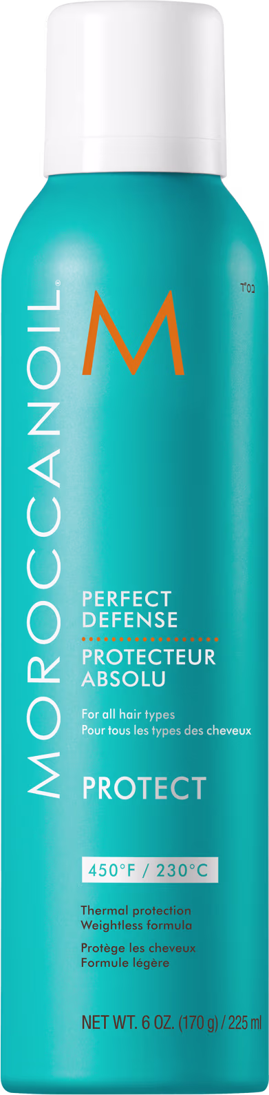 A imagem mostra o Protetor Térmico Moroccanoil Perfect Defense 225ml, com frasco cilíndrico na cor azul turquesa e detalhes em laranja e branco. O texto destaca que o produto oferece proteção térmica de até 450°F/230°C.
