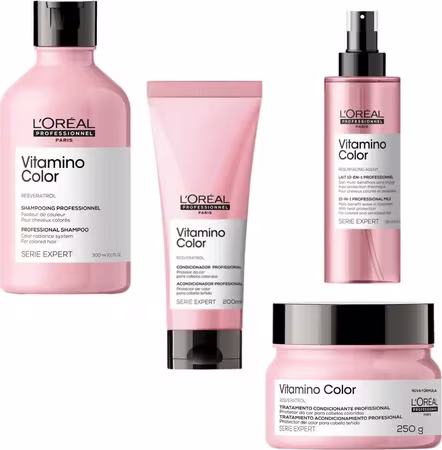 A imagem mostra uma linha de produtos de cuidados capilares da marca L'Oréal Professionnel, chamada Vitamino Color. Há 4 frascos plásticos rosa com tampas pretas, sendo um shampoo, um condicionador e uma máscara capilar e um leave-in.