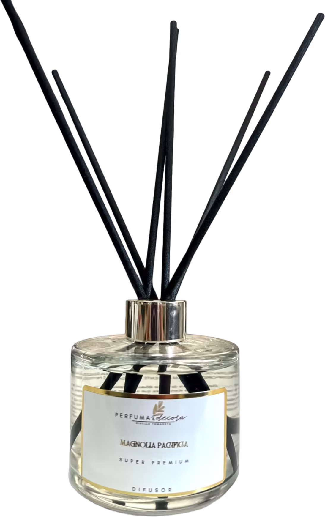 Difusor de aromas em frasco de vidro transparente. Contém hastes pretas que saem do bocal para difundir o aroma. Rótulo na parte frontal com o texto "Perfuma & Decora", "Magnolia Pacifica" e "Super Premium".