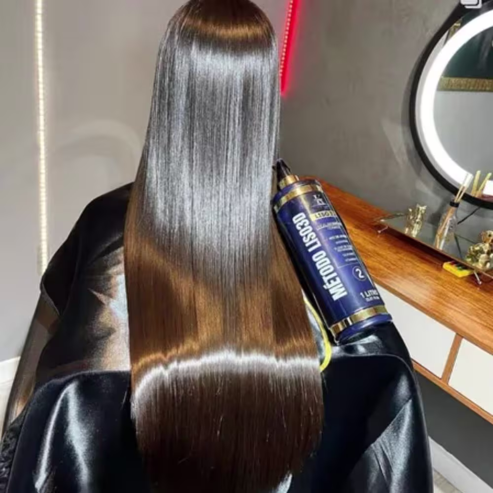 O produto apresentado é um tratamento capilar da marca Kerastinni. É um frasco cilíndrico azul escuro com detalhes dourados na embalagem. O frasco está posicionado ao lado de longos cabelos lisos e brilhantes, que parecem ter sido tratados com o produto.