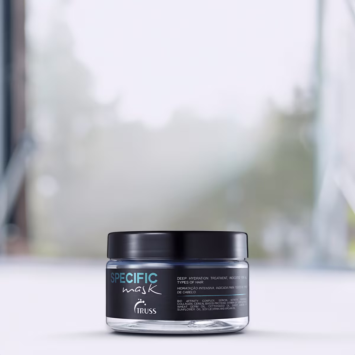 A imagem mostra um pote redondo de máscara capilar.