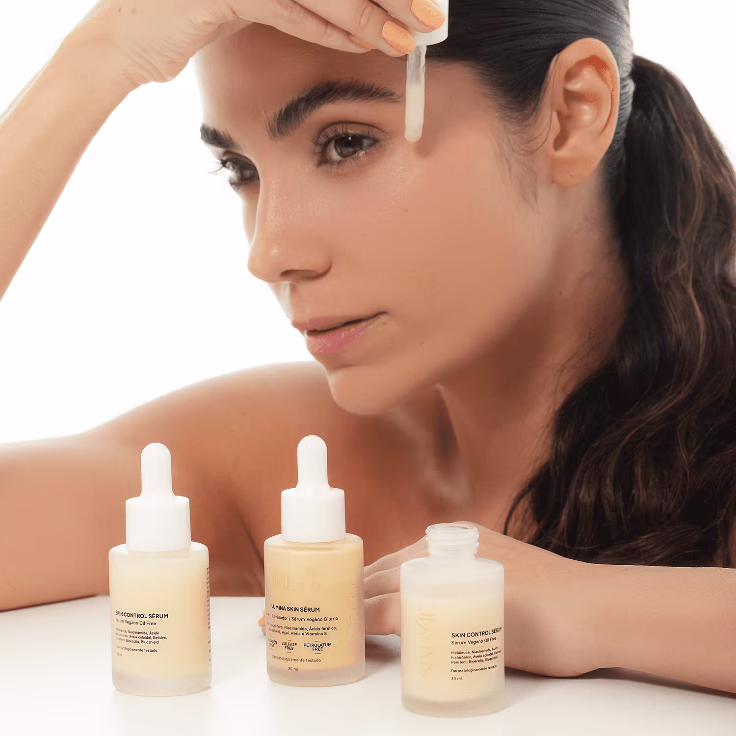 A imagem mostra uma modelo usando o produto, com três frascos em sua frente.