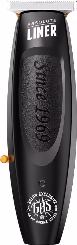 Máquina de acabamento da marca GA.MA Italy, da linha Absolute Liner. O produto tem um design preto fosco com detalhes em laranja. A embalagem é um aparador de plástico alongado com uma lâmina de corte na extremidade.