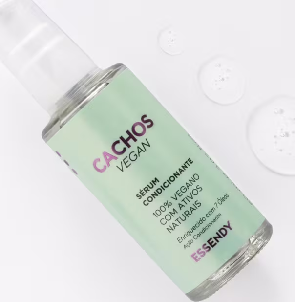 Sérum condicionante vegano. O rótulo exibe o nome da marca em letras verdes e roxas, indicando que o produto é 100% vegano. O frasco possui um design simples e minimalista, com uma tampa transparente que permite visualizar o conteúdo do produto.