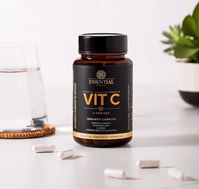 A imagem mostra um frasco redondo marrom com rótulo preto e letras douradas com cápsulas em volta numa superfície branca.