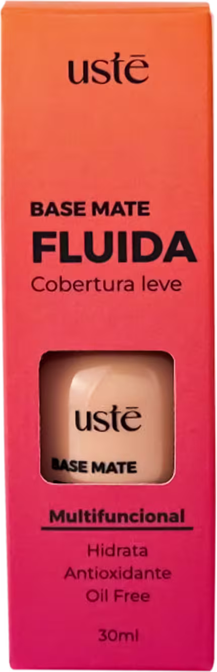 Base na caixa de embalagem retangular laranja com o nome do produto "BASE MATE FLUIDA" em letras pretas. Pequena janela exibe o tom da base.
