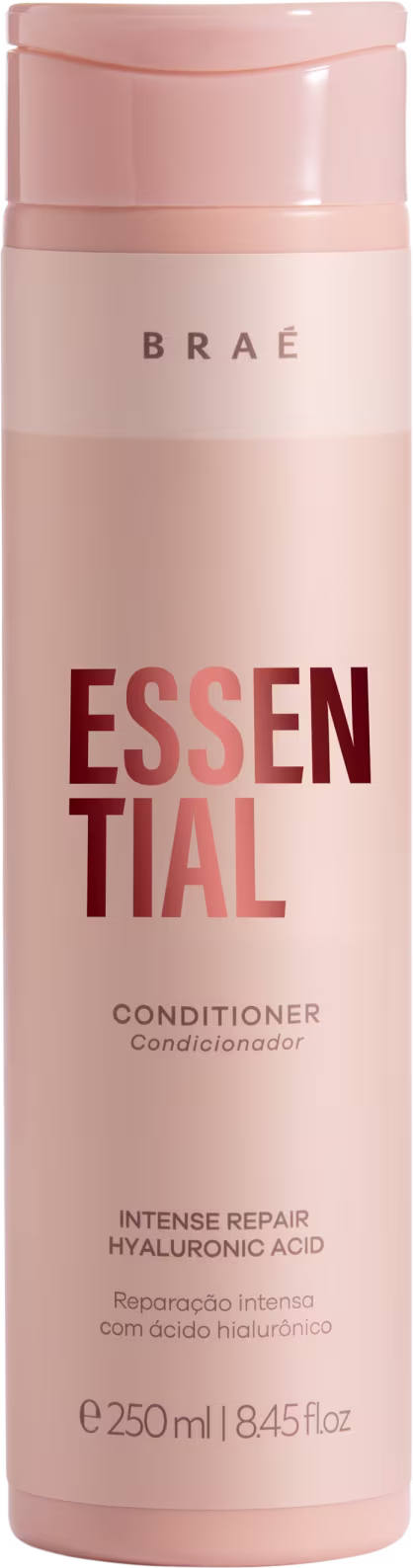 Condicionador Essential da marca Brae. Embalagem cilíndrica de plástico rígido na cor rosa claro. Rótulo com o nome do produto "Essential" em letras grandes vermelhas e a palavra "Conditioner" abaixo em letras menores.
