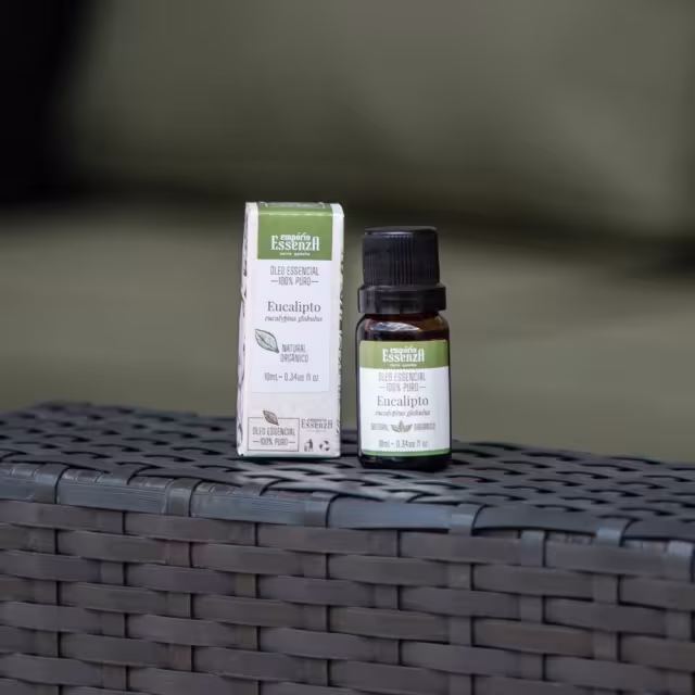 Caixa e frasco de óleo essencial de eucalipto da marca Empório Essenza, com rótulos em verde e preto. O óleo essencial está acondicionado em um frasco de vidro com tampa preta.