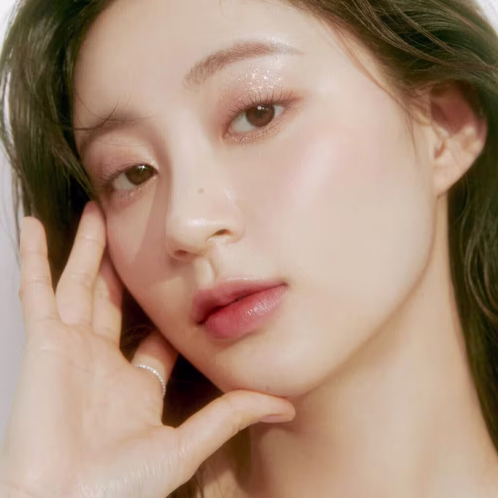 Ambiente de beleza com iluminação suave e tons neutros, destacando o rosto da modelo com maquiagem sutil da marca rom&nd.