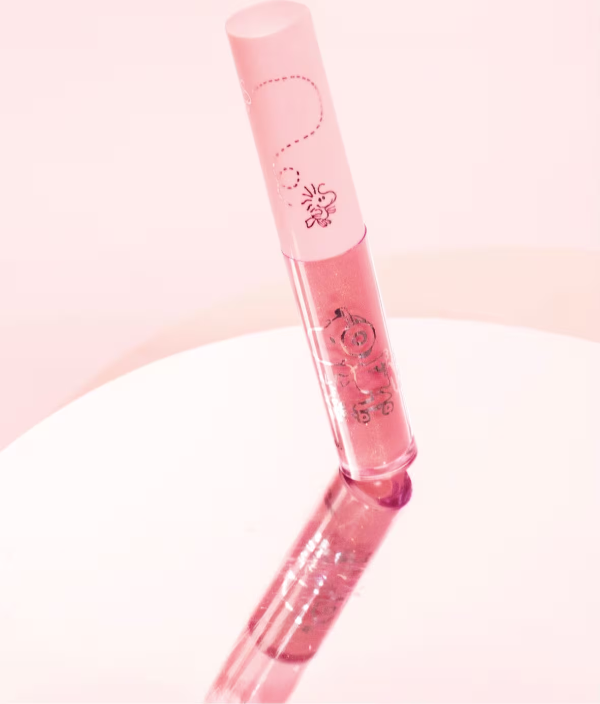 O produto apresentado na imagem é um gloss da marca Cia. Beauty. Possui uma embalagem cilíndrica de cor rosa clara, com um design simples e elegante.