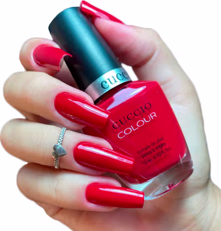 Modelo com as unhas pintadas segurando o frasco do Esmalte Cremoso Cuccio Brasil Colour A Pisa My Heart 1120 13ml.