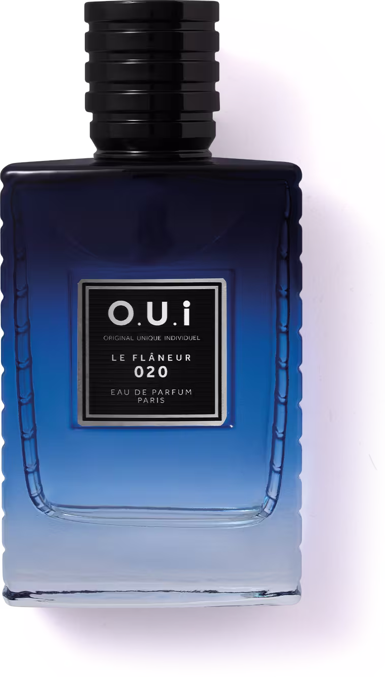 A imagem mostra um frasco azul escuro de eau de parfum da marca O.U.i. O frasco tem um formato retangular com detalhes em alto relevo, dando-lhe uma aparência sofisticada. Na parte frontal, há um rótulo preto com o nome da marca e do Eau de Parfum.