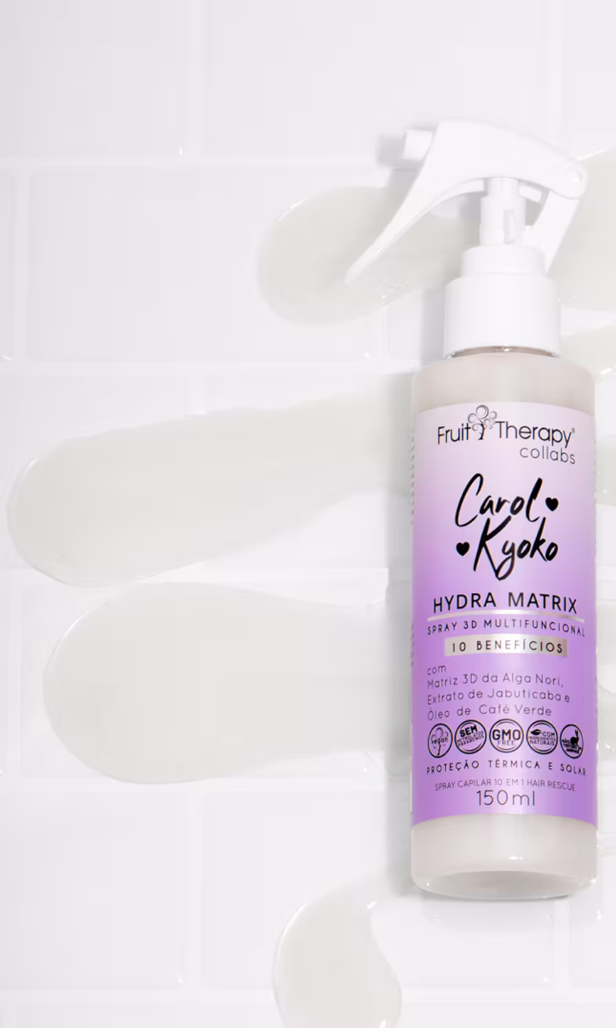 A imagem mostra a embalagem do spray de tratamento de 150ml no centro de uma superfície branca, com o líquido do produto espalhado em zigue-zague, decorando o cenário.