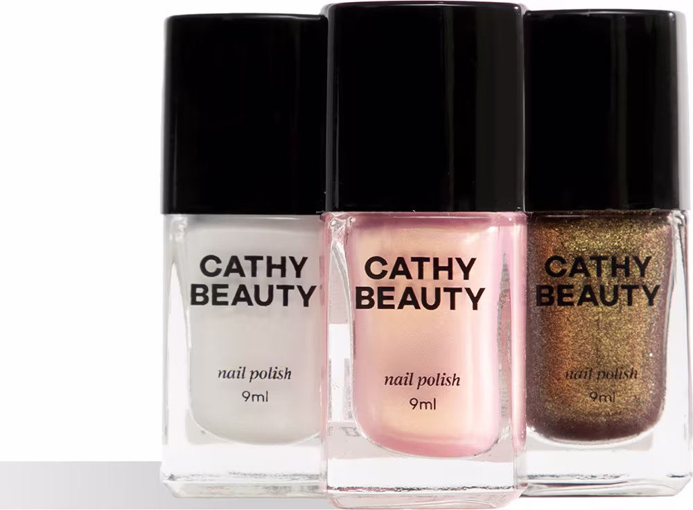 Três frascos de esmalte da marca Cathy Beauty, nas cores branco, rosa e dourado brilhante. Cada frasco possui 9ml de produto e apresenta o nome da marca em destaque.
