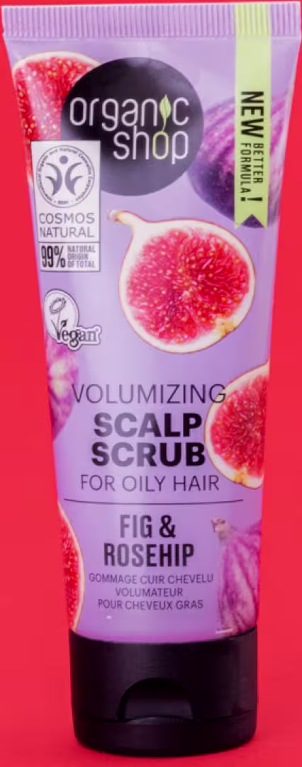 A imagem mostra o esfoliante capilar em embalagem plástica tubo com tampa preta. Predominam as cores roxo, verde claro e preto. Rótulo com imagens de figos e fundo da imagem em tom vermelho.