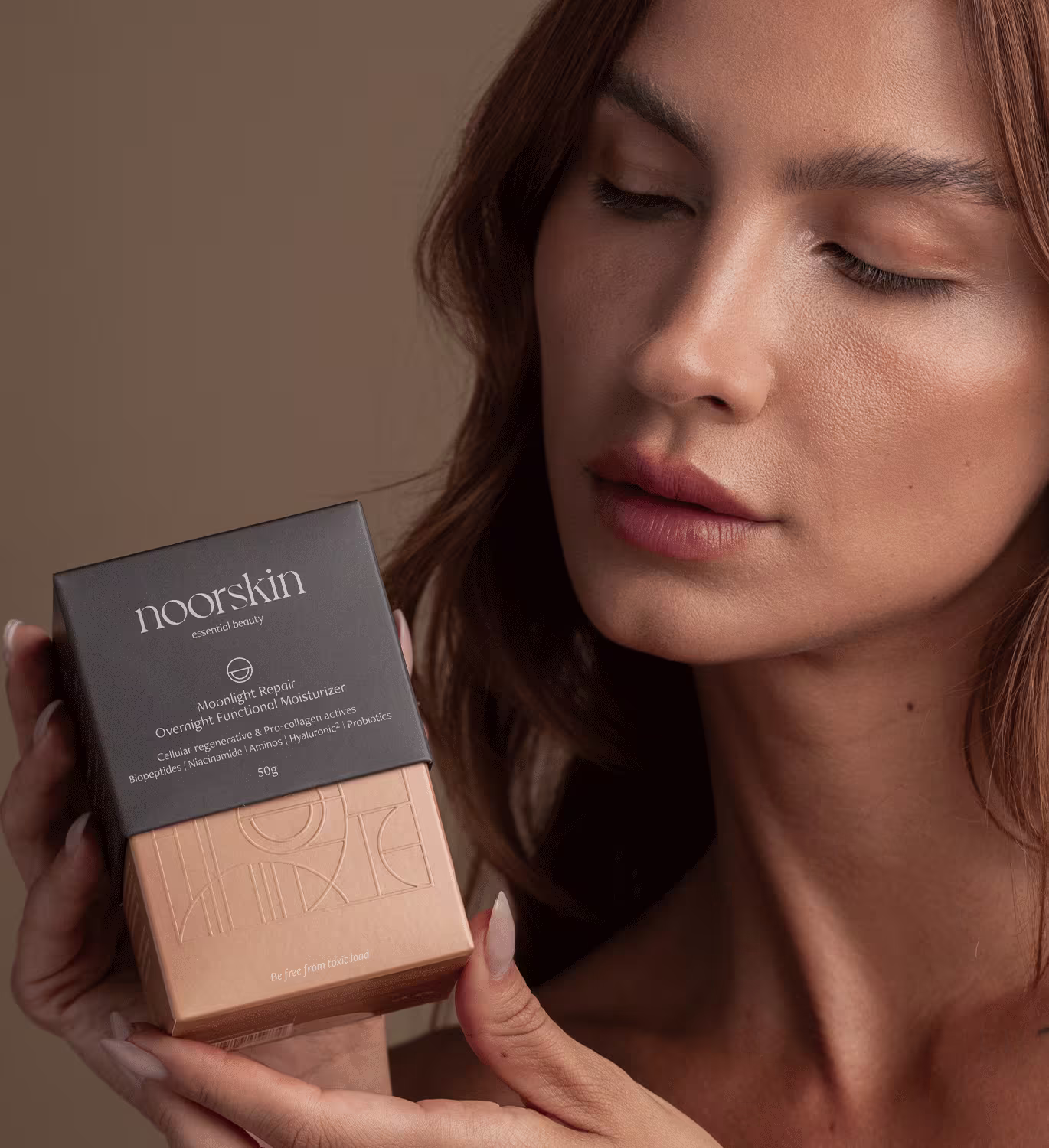 Modelo mostra a caixa do Creme Noorskin Essential Beauty Moonlight Repair