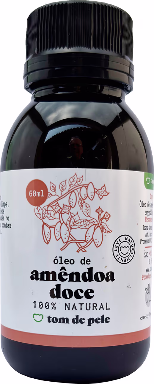 Frasco de óleo de amendoa doce 100% natural da marca Tom de Pele, com rótulo branco e laranja, contendo 60ml do produto.