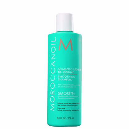 A imagem mostra o Shampoo Moroccanoil Smoothing 250ml. A embalagem é de cor azul turquesa e tem letras na cor laranja, branco e preto. Também apresenta informações sobre os benefícios do produto.