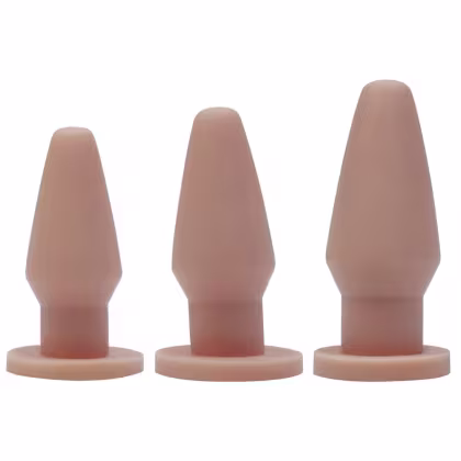 Três plugs anais de silicone em diferentes tamanhos, com tonalidade de pele, apresentados em um fundo branco.