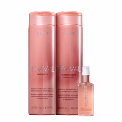 Dois frascos de shampoo e condicionador da linha Revival da marca Brae, em embalagens rosadas com detalhes em dourado, e um frasco de óleo capilar da mesma marca.