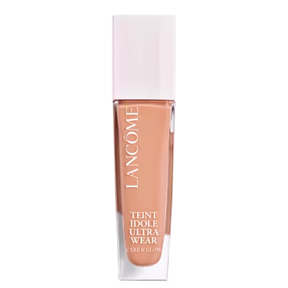 Frasco de maquiagem Lancôme Teint Idole Ultra Wear, com embalagem branca e detalhes em cobre. O produto é descrito como um "Care & Glow" com acabamento natural e duradouro.