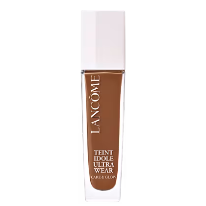 Frasco de maquiagem Lancôme Teint Idole Ultra Wear, com embalagem branca e tampa dourada. O rótulo destaca o nome do produto e suas características de "Care & Glow".