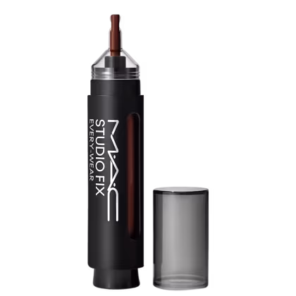 Corretivo Studio Fix da marca M·A·C, embalagem em formato de caneta com frasco preto e parte transparente para mostrar a cor do produto. Ao lado a tampa em tom preto translúcido. Cores predominantes são preto e branco.