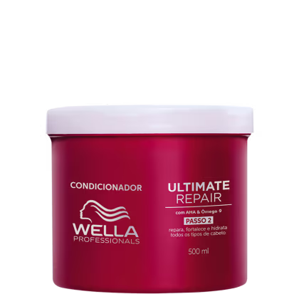 É um condicionador para cabelos da marca Wella Professionals. O produto vem em uma embalagem vermelha com tampa branca. A embalagem tem capacidade de 500ml. O rótulo indica que é o "Ultimate Repair Passo 2", um condicionador para reparar e hidratar.