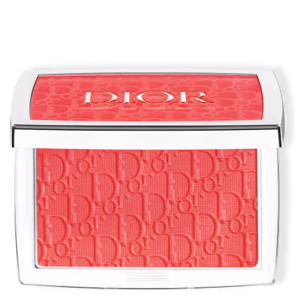 A imagem mostra a paleta com o blush. Ela possui um formato retangular em tom metalizado. No topo está escrito a logo Dior no tom coral do produto. O pó também é texturizado com a logo da marca.