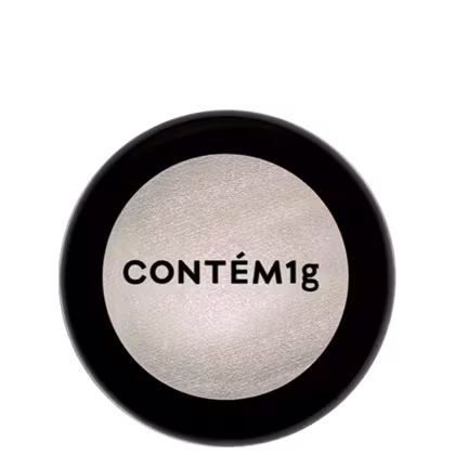 A imagem mostra uma embalagem de pó iluminador cor prateada e no centro, a logo da marca em preto.