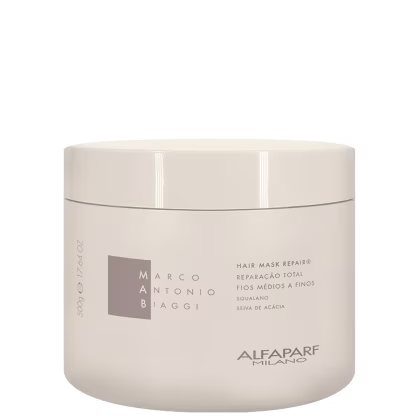 A imagem mostra a máscara Repair Mask 500g da marca MAB Marco Antônio de Biaggi by Alfaparf Milano. O produto vem em uma embalagem cilíndrica na cor branca, com o logotipo e informações do produto: reparação total para fios médios a finos.