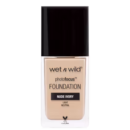 A imagem mostra uma embalagem de base líquida da marca Wet n Wild. É o produto PhotoFocus Foundation. A embalagem é um frasco retangular com o rótulo frontal que exibe o nome do produto e a marca.