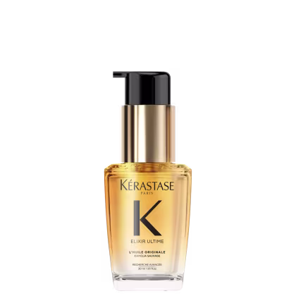 A imagem mostra o óleo capilar da marca Kérastase. O frasco é transparente, permitindo ver o líquido dourado dentro. O frasco tem um formato cilíndrico e uma bomba dosadora preta no topo. O rótulo apresenta letras pretas sobre um fundo dourado.