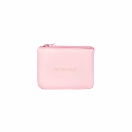 Pequeno nécessaire de cor rosa claro retangular com zíper na parte superior. Na parte frontal, está o nome da marca "océane" em letras minúsculas. O material parece ser uma espécie de couro sintético ou tecido emborrachado. O design é minimalista e clean.