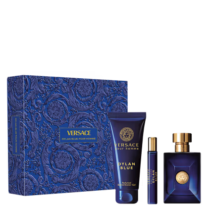 A imagem mostra um frasco de perfume retangular azul escuro com detalhes dourados, um frasco menor de amostra do mesmo perfume, e um tubo de gel de banho. Os itens estão embalados em uma caixa decorativa azul escura com um padrão floral estampado.