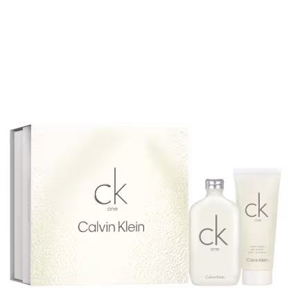 Frasco de perfume cilíndrico branco fosco com o logotipo "ck one" em letras minúsculas cinza. Caixa retangular branca texturizada com o nome "ck one Calvin Klein" impresso. Pequeno frasco tubular branco fosco com o rótulo "ck one body wash".